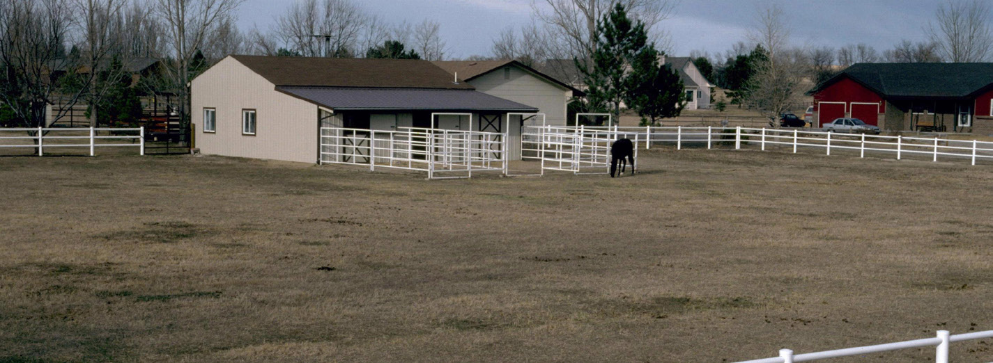A barn surrounded by fenced pasture