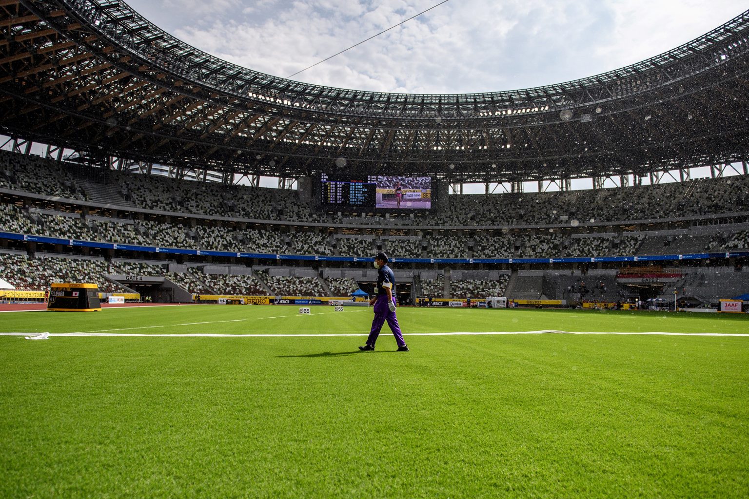 An official walks across the infield of the National Stadium in Tokyo, home of the 2020 Olympic Games. A UGA-bred grass will be used on the field