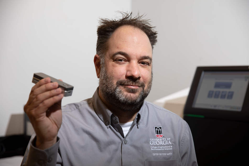 Henk den Bakker holds new technology with monitor in the background