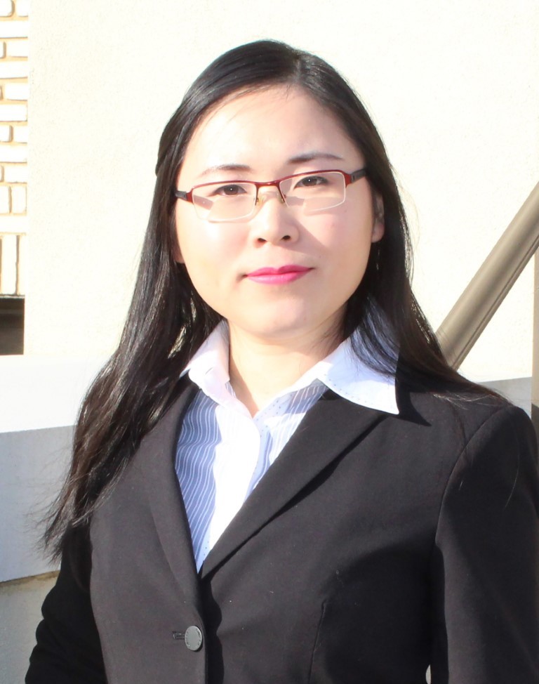 Yangxuan Liu, who specializes in cotton economics, stands outdoors in a suit