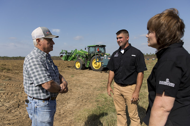Farmer Willard Mims talks with Seminole County Agriculture and Natural Resources Agent Andrew Warner and Southwest District Director Andrea Scarrow about the damage inn one of his peanut fields on his Seminole County farm