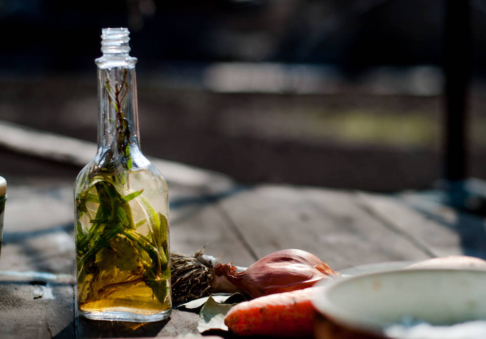 A bottle of oil infused with herbs and vegetables