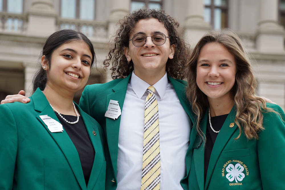 Wearing green jackets, state 4-H officers Venya Gunjal, Kareem El-Gayyar, Hannah Jones gather together during 4-H Day at the Capitol.