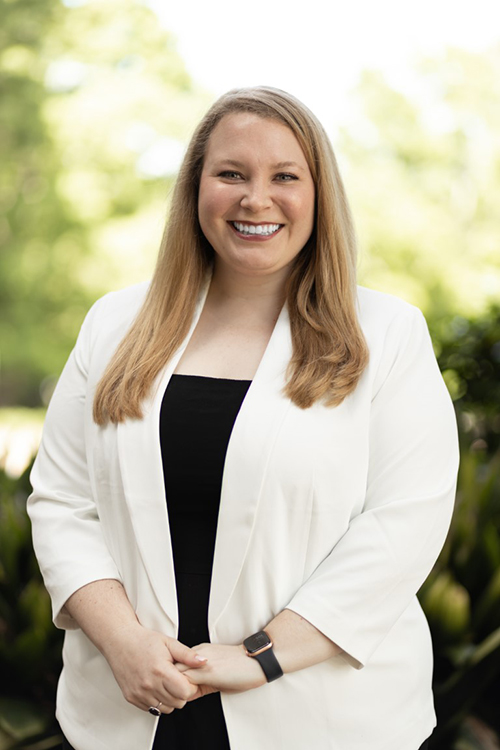 Jessica Fife wears a white blazer over a black shirt.