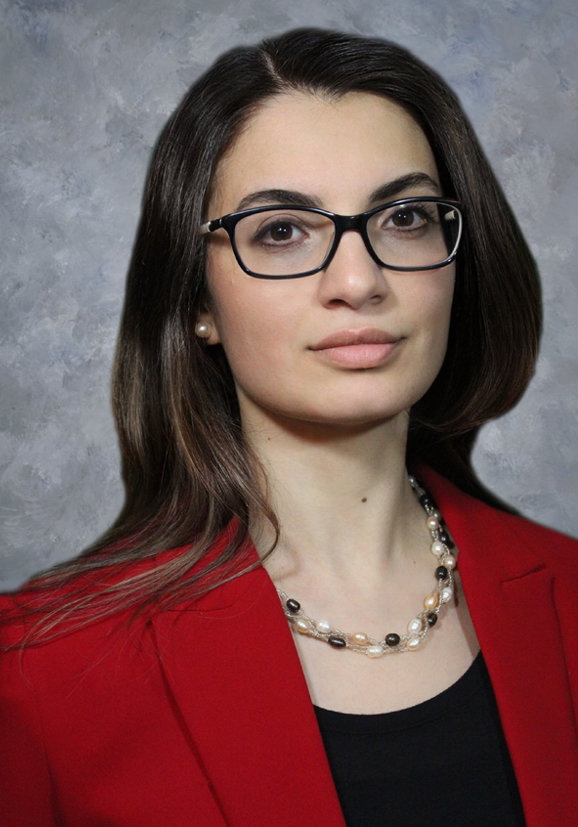 Malak Esseili wearing a red blazer in her studio headshot