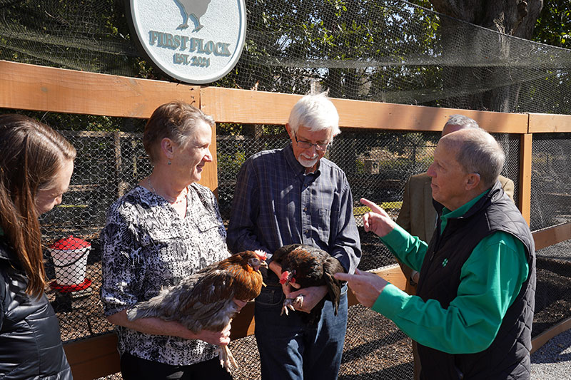 Georgia 4-H leader Melanie Biersmith (from left) listens to Centurion Poultry owners Gijs and Louis Schimmel describe the new hens joining the First Flock with National 4-H representative Bo Ryles.