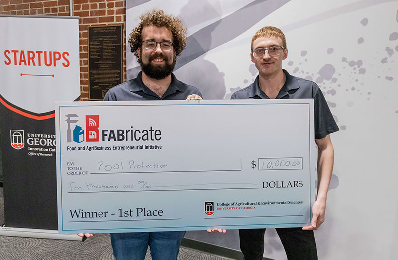 UGA engineering students Pool Protection Technologies, founded by UGA College of Engineering students Garrett Stigall and Guy Gober hold an oversized check for $10,000 as winners of the 2024 FABricate Entrepreneurial contest.
