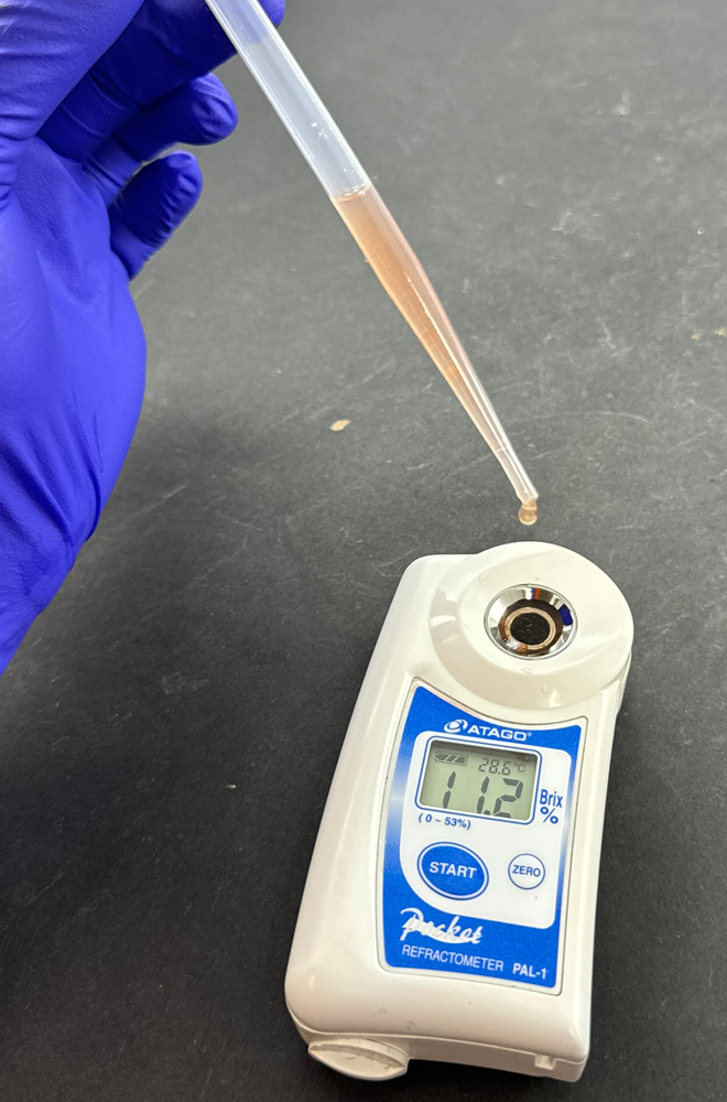 A digital refractometer looks like a small rectangular piece of equipment with a circular area at the top to hold the sample being tested.