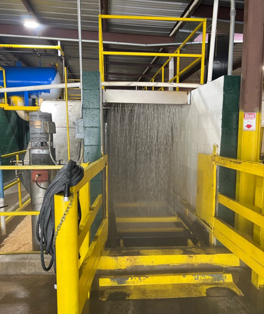 A hyrdocooling system consists of two cinderblock walls to contain the water and prevent contamination, rails to guide trays or bins, and a curtain of water to cool the fruit.