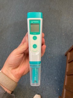 A small handheld device with two buttons, a liquid crystal display, and a sheathed sensor.