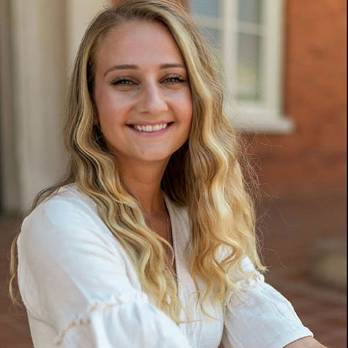 Olivia Erskine smiles outdoors on the UGA campus